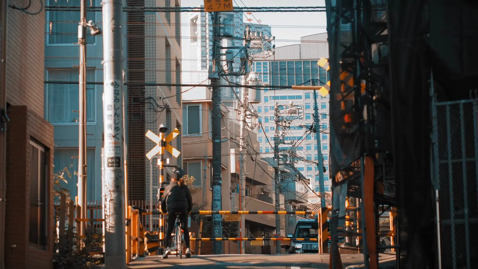 A railway crossing in the morning light, a cyclist waiting
