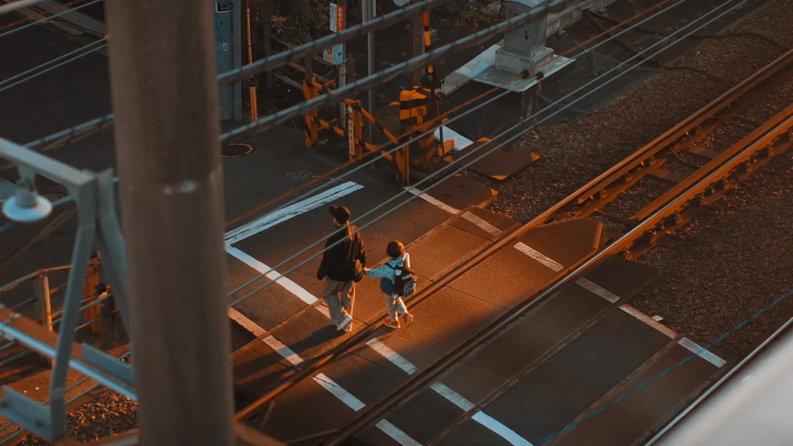 A railway crossing from above, two people crossing