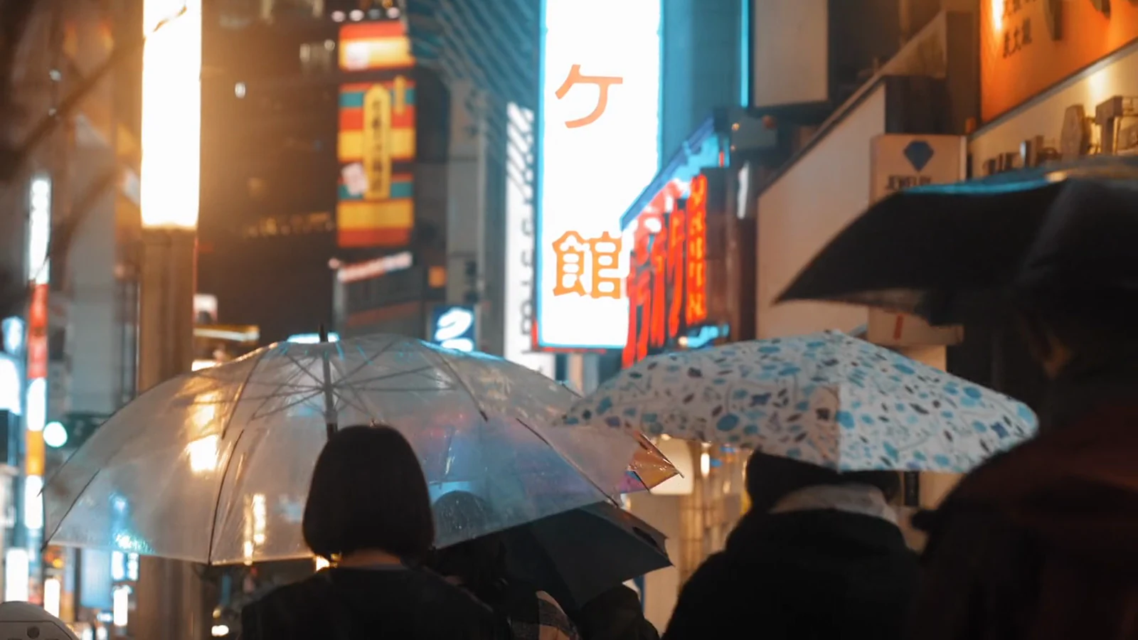 Umbrellas in a rainy neon street
